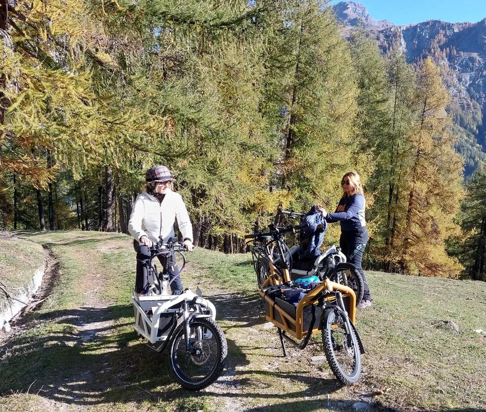 BigaAdventure 2025, Cervinia — due biker sul sentiero tra i larici